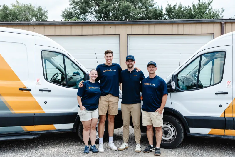 GoldenHome Club team smiling in front of their service vans