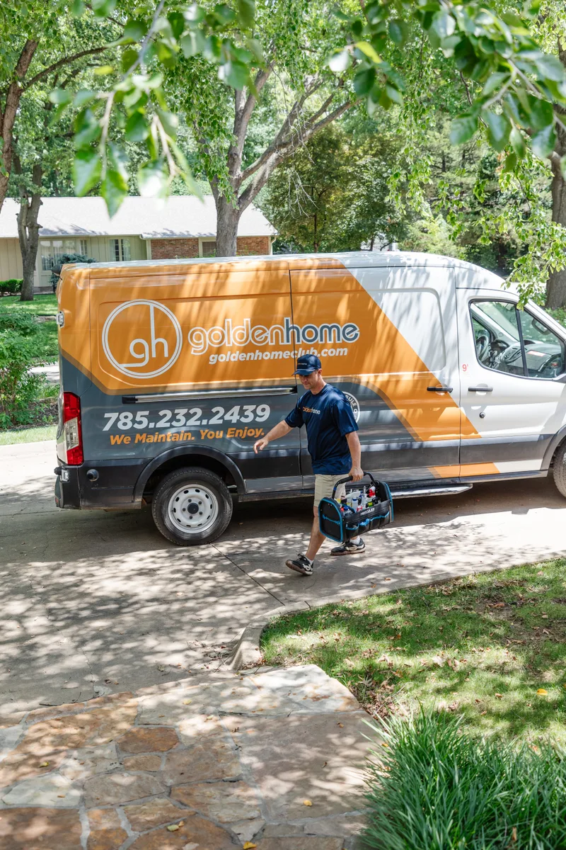 GoldenHome technician approaching a Topeka home with tools from the service van