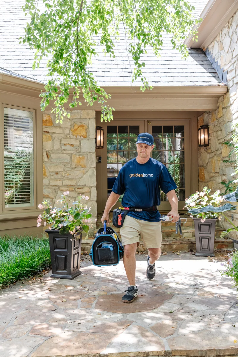 GoldenHome technician leaving a customer's home with tools after a service visit